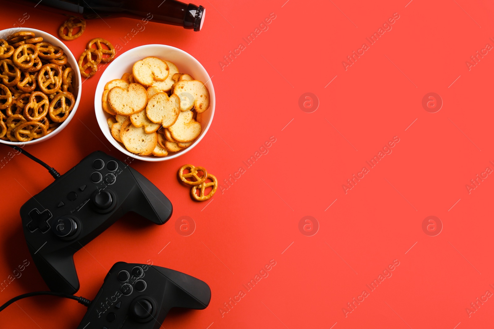 Photo of Flat lay composition with video game controllers, snacks and space for text on color background