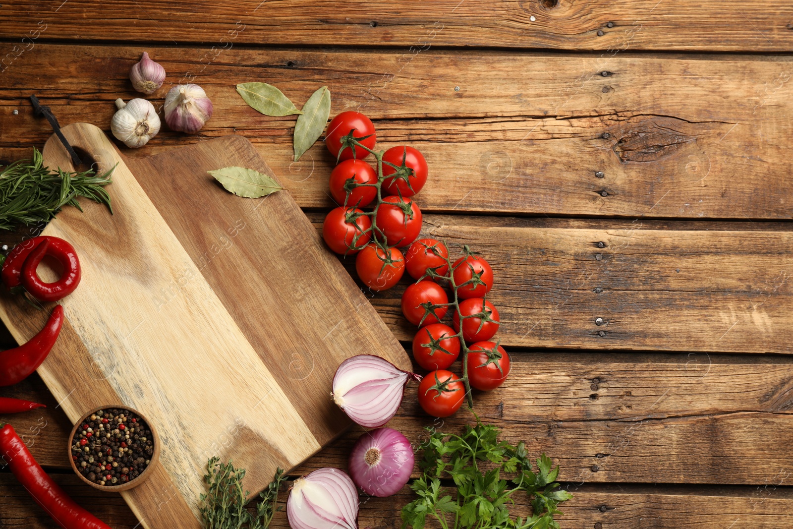 Photo of Cutting board and vegetables on wooden table, flat lay with space for text. Cooking utensil