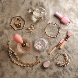 Composition with perfume bottles, cosmetics and jewellery on fabric, flat lay