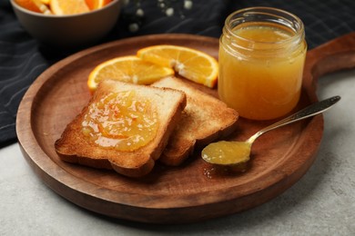 Photo of Delicious toasts with orange marmalade on light grey table