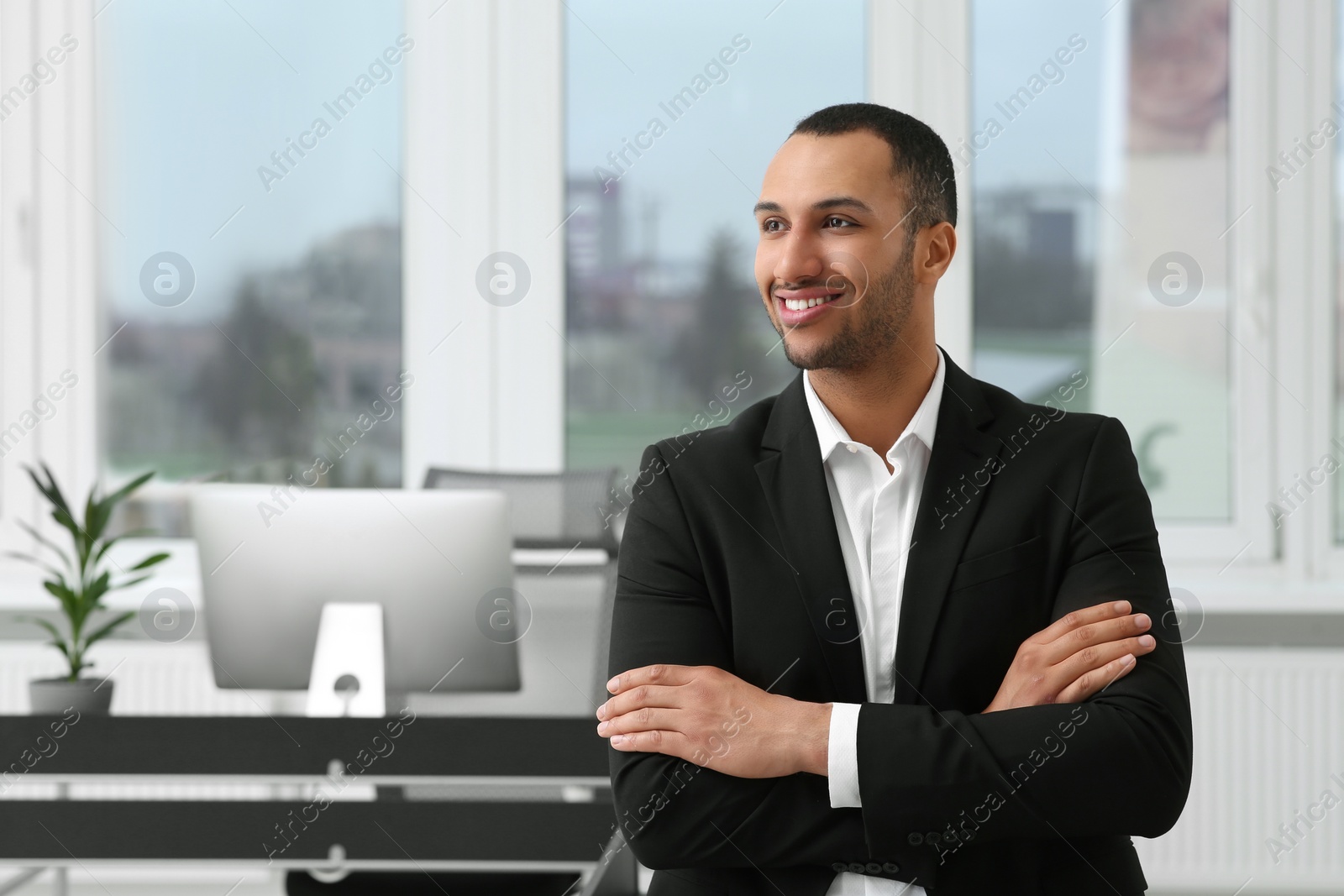 Photo of Smiling young businessman in modern office. Space for text