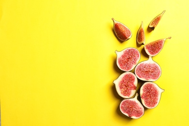 Photo of Cut ripe figs on color background, top view. Space for text