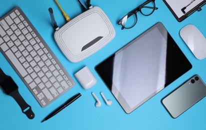 Photo of Flat lay composition with modern Wi-Fi router on light blue background