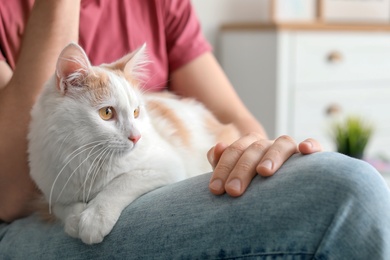 Photo of Young man with cute cat at home