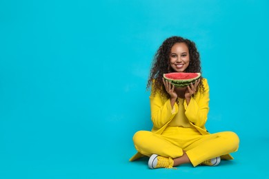 Photo of Beautiful young African American woman with watermelon on light blue background. Space for text