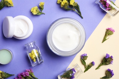 Flat lay composition with jars of body cream on color background