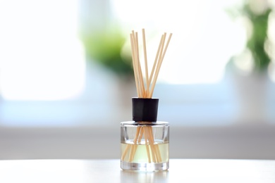 Handmade reed freshener on table against blurred background