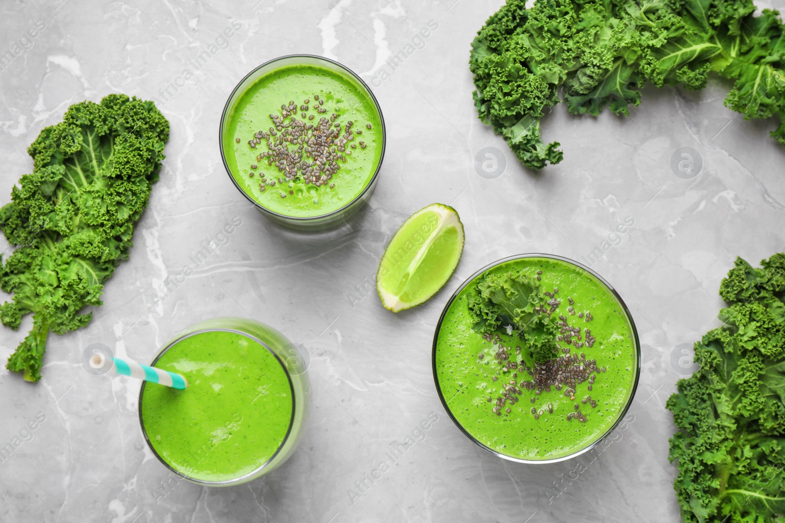 Photo of Tasty kale smoothie on light grey marble table, flat lay