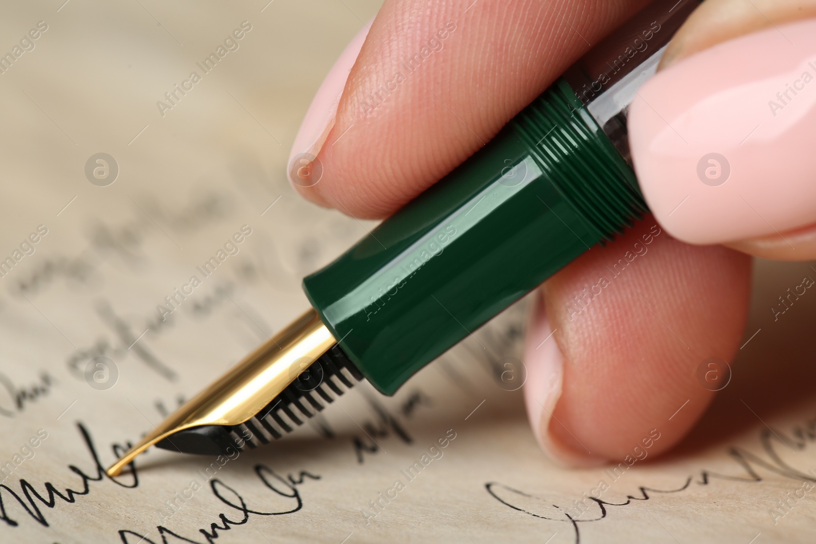 Photo of Woman writing letter with fountain pen, closeup