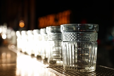 Row of empty clean glasses on counter in bar. Space for text