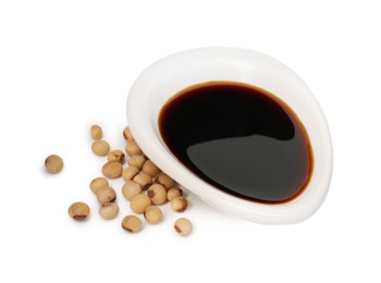 Photo of Tasty soy sauce in gravy boat and soybeans isolated on white