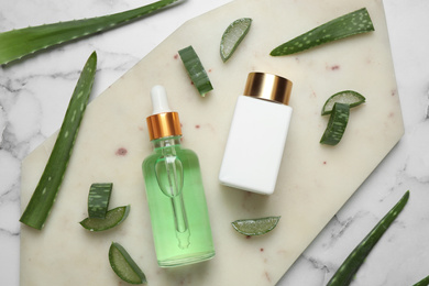 Photo of Flat lay composition with aloe vera and cosmetic products on white marble background