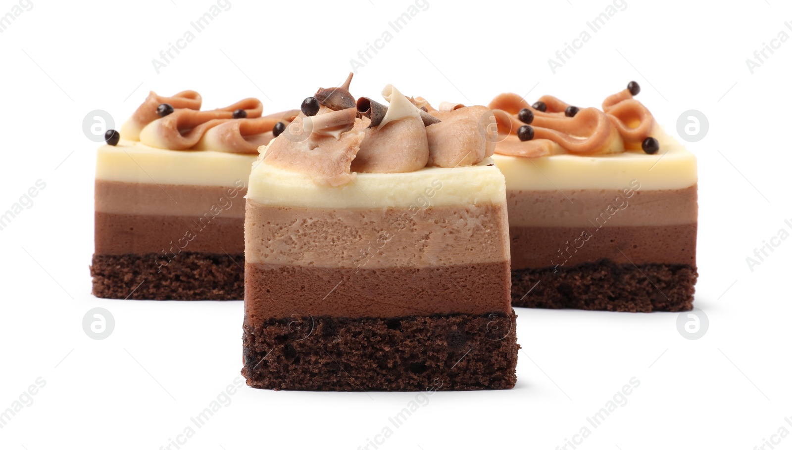 Photo of Pieces of triple chocolate mousse cake on white background