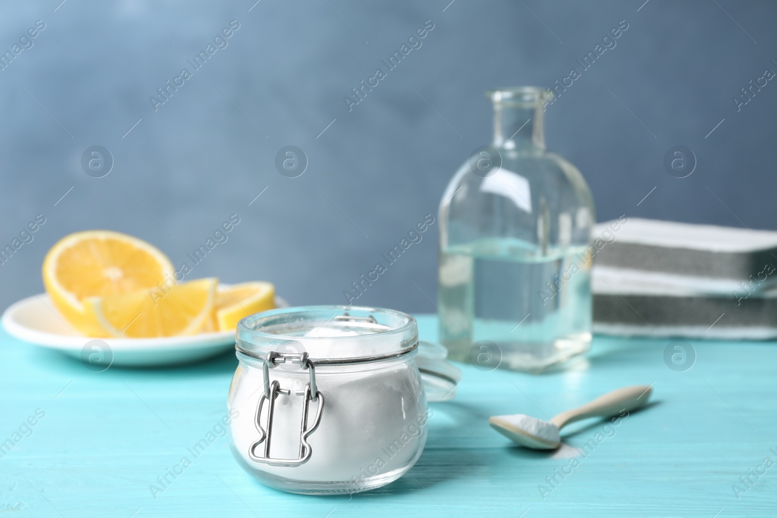 Photo of Baking soda in glass jar on light blue wooden table