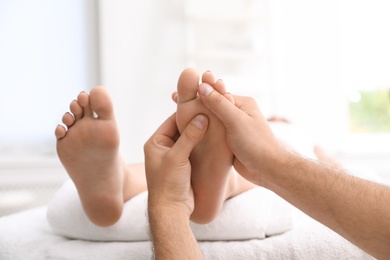 Photo of Young woman receiving massage in salon, closeup