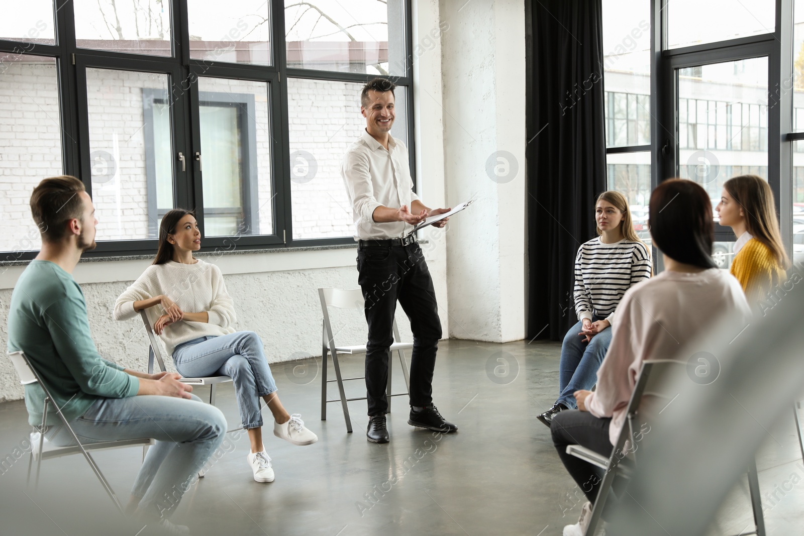 Photo of Psychotherapist working with patients in group therapy session indoors