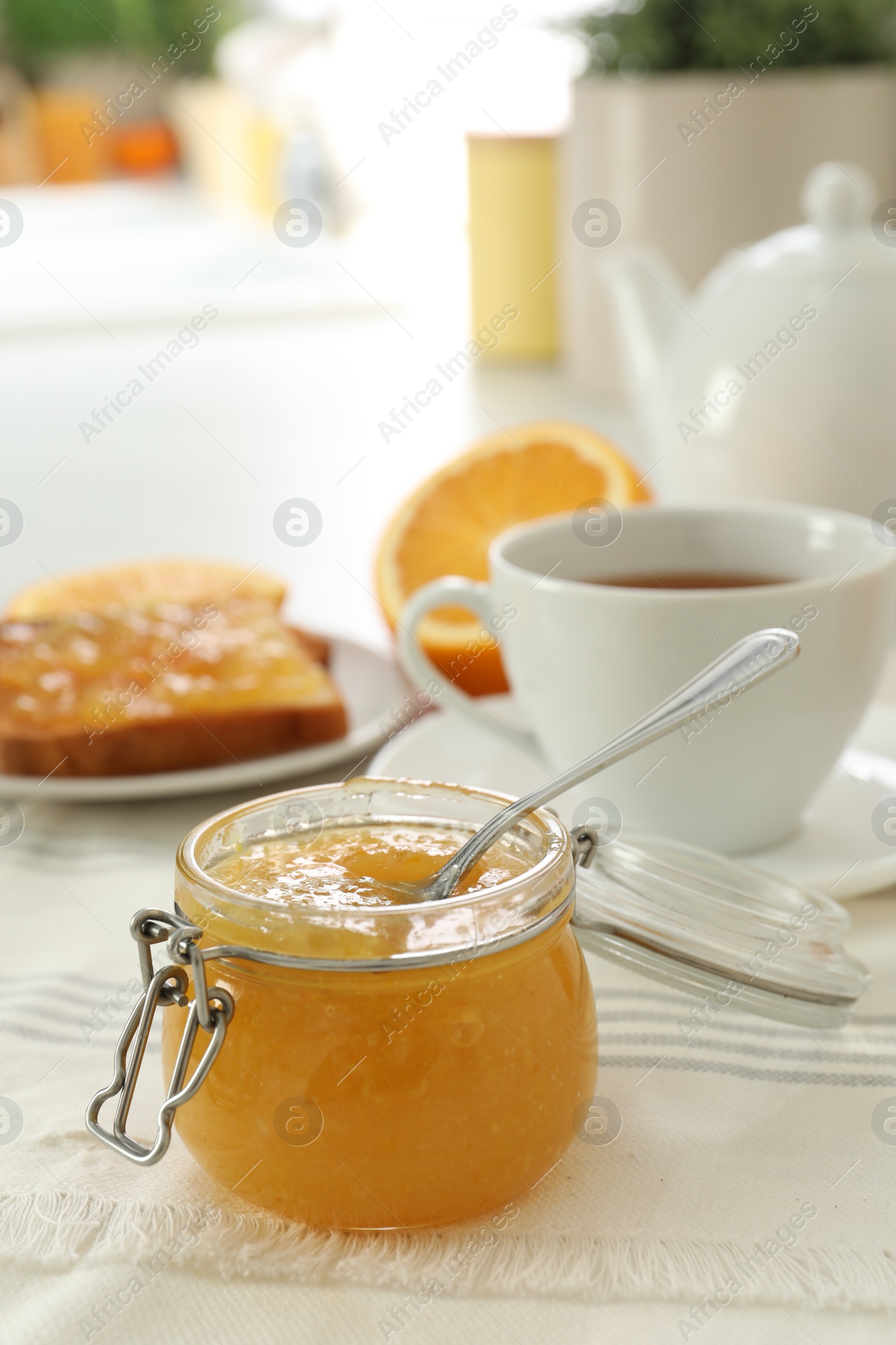 Photo of Breakfast with delicious orange marmalade on table. Space for text