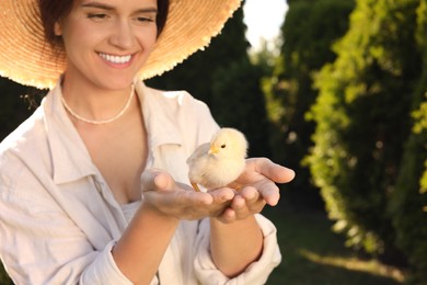 Happy woman with cute chick on sunny day, selective focus