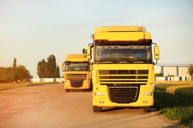 Photo of Modern yellow trucks parked on country road