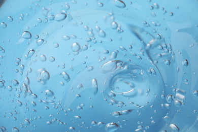 Photo of Sample of light blue cosmetic gel as background, closeup