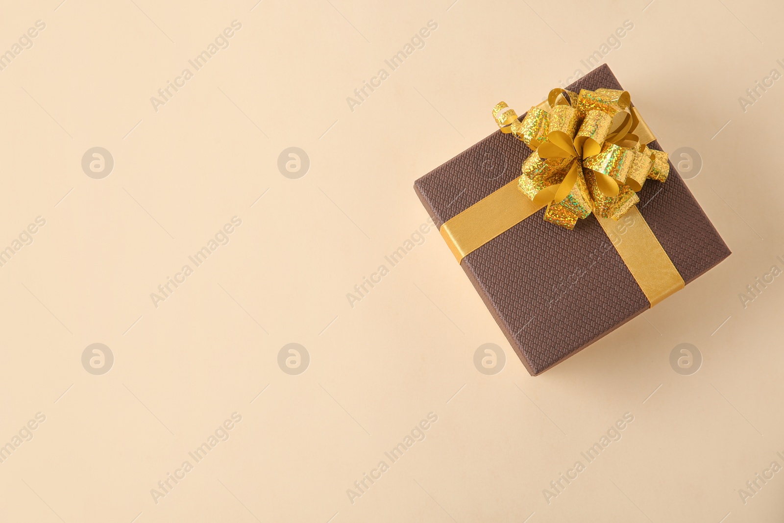 Photo of Beautiful gift box on beige background, top view. Space for text