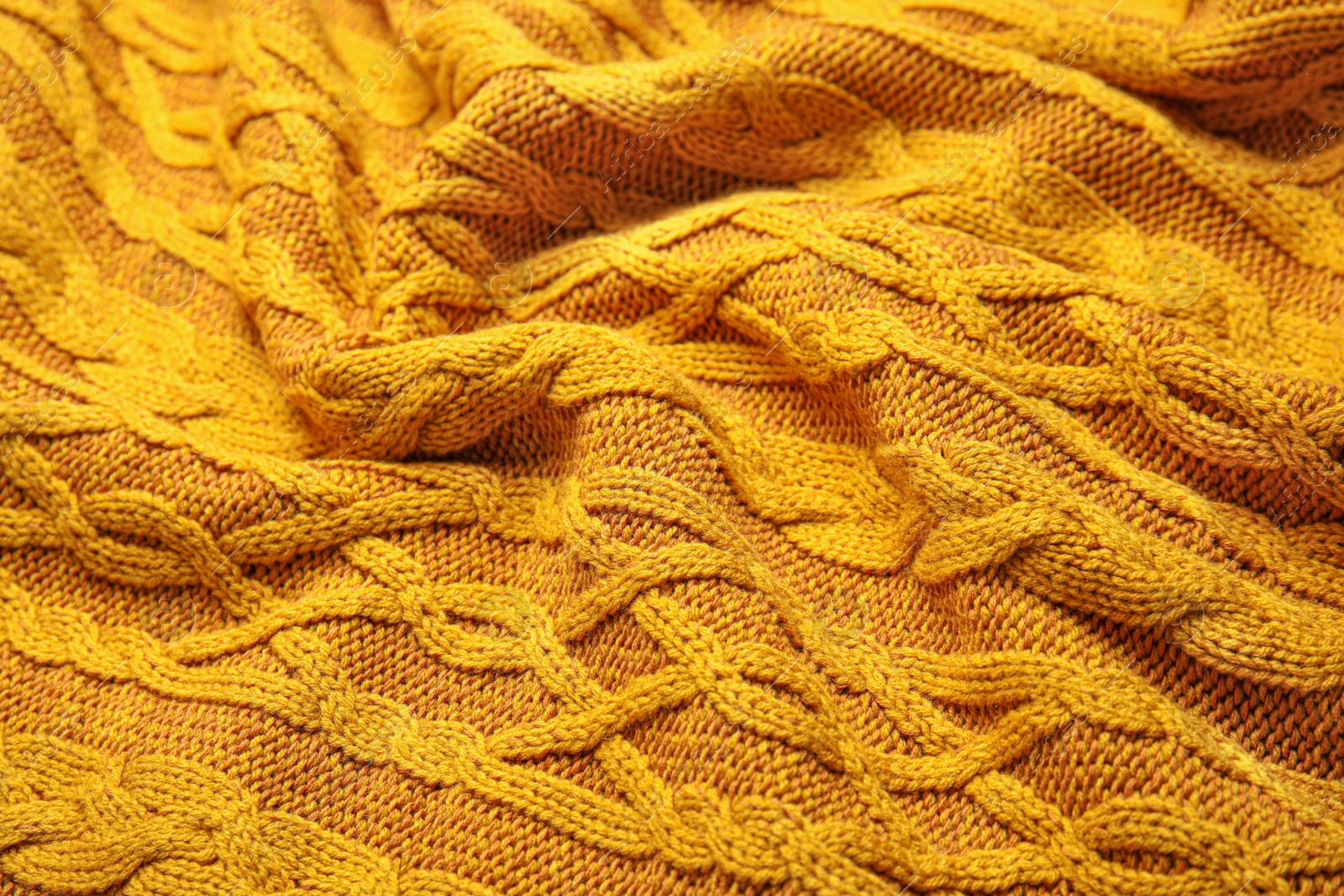 Photo of Soft orange knitted plaid as background, closeup