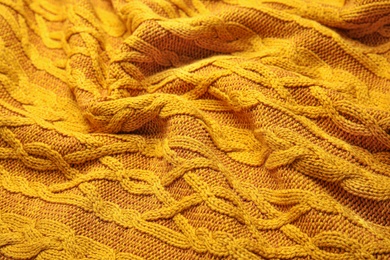 Soft orange knitted plaid as background, closeup