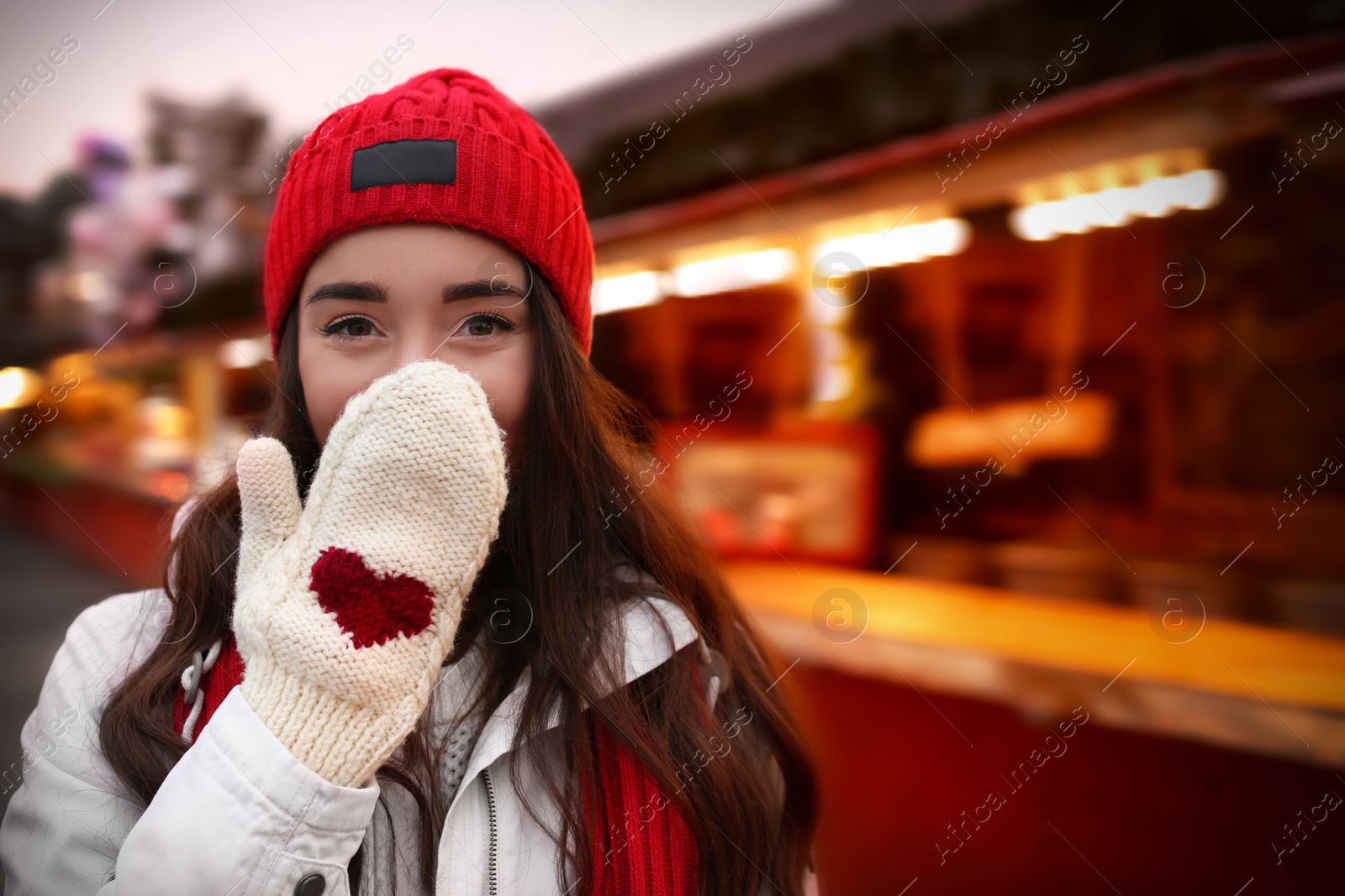 Photo of Young woman spending time at Christmas fair, space for text