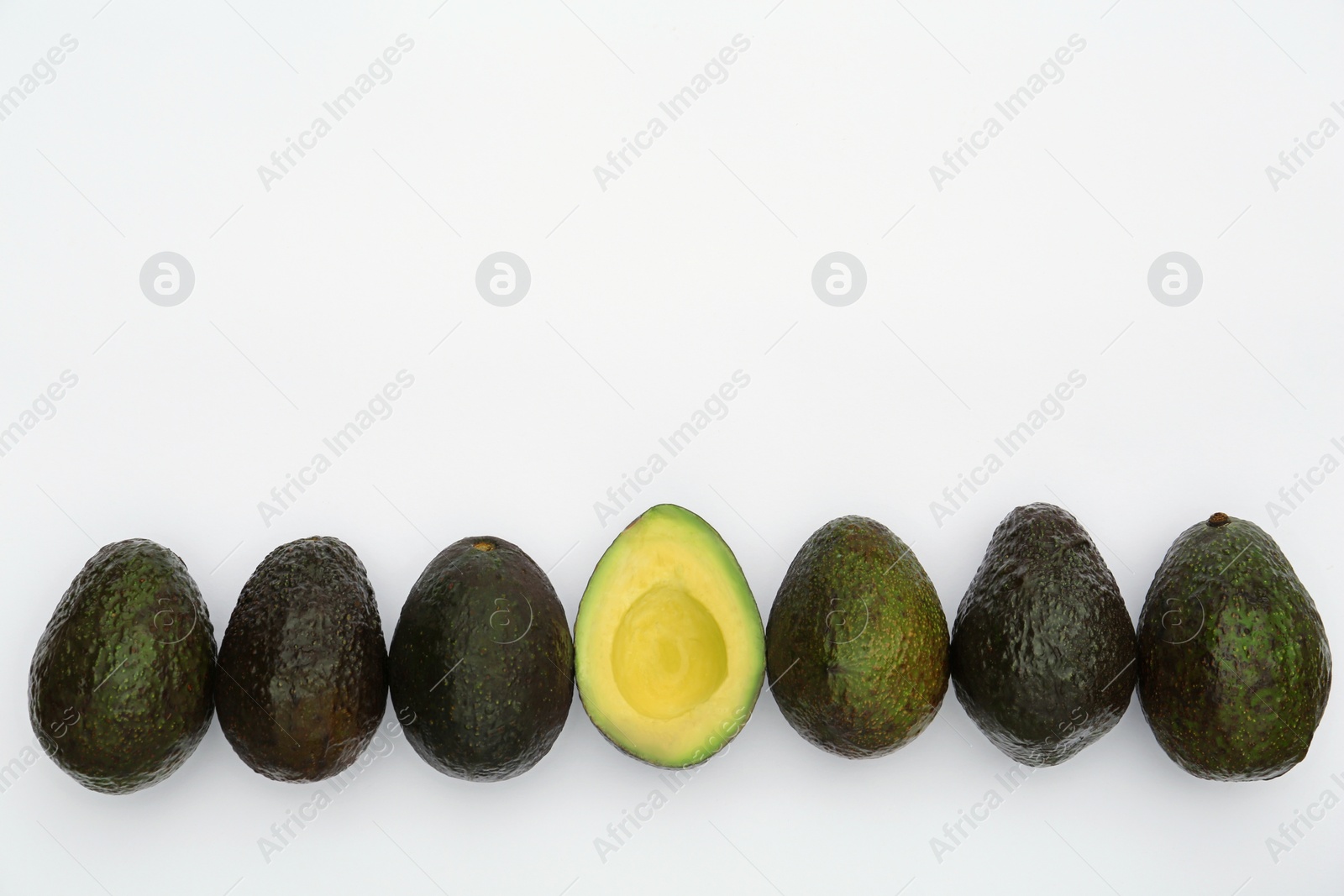 Photo of Tasty whole and cut avocados on white background, flat lay. Space for text