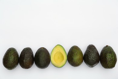 Photo of Tasty whole and cut avocados on white background, flat lay. Space for text