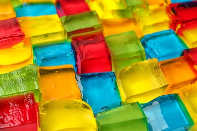 Tasty colorful jelly cubes as background, closeup