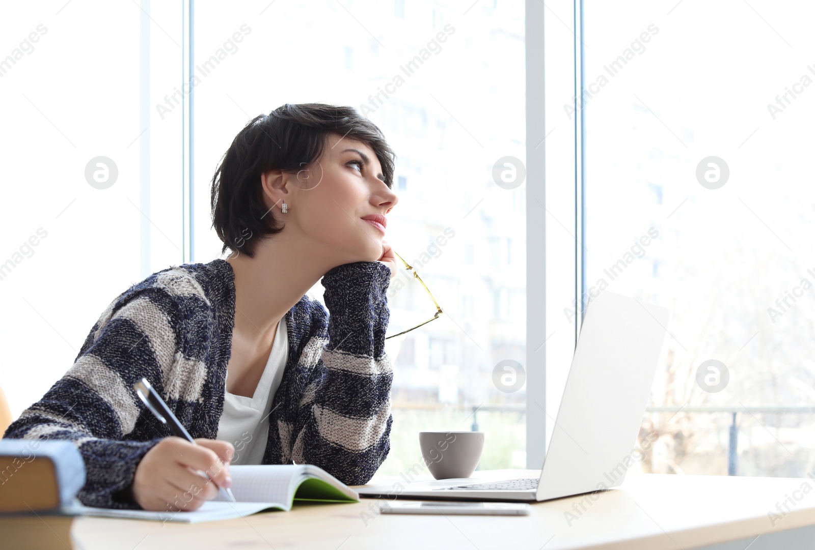 Photo of Young woman working at desk. Home office