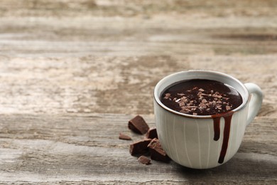 Photo of Yummy hot chocolate in cup on wooden table. Space for text