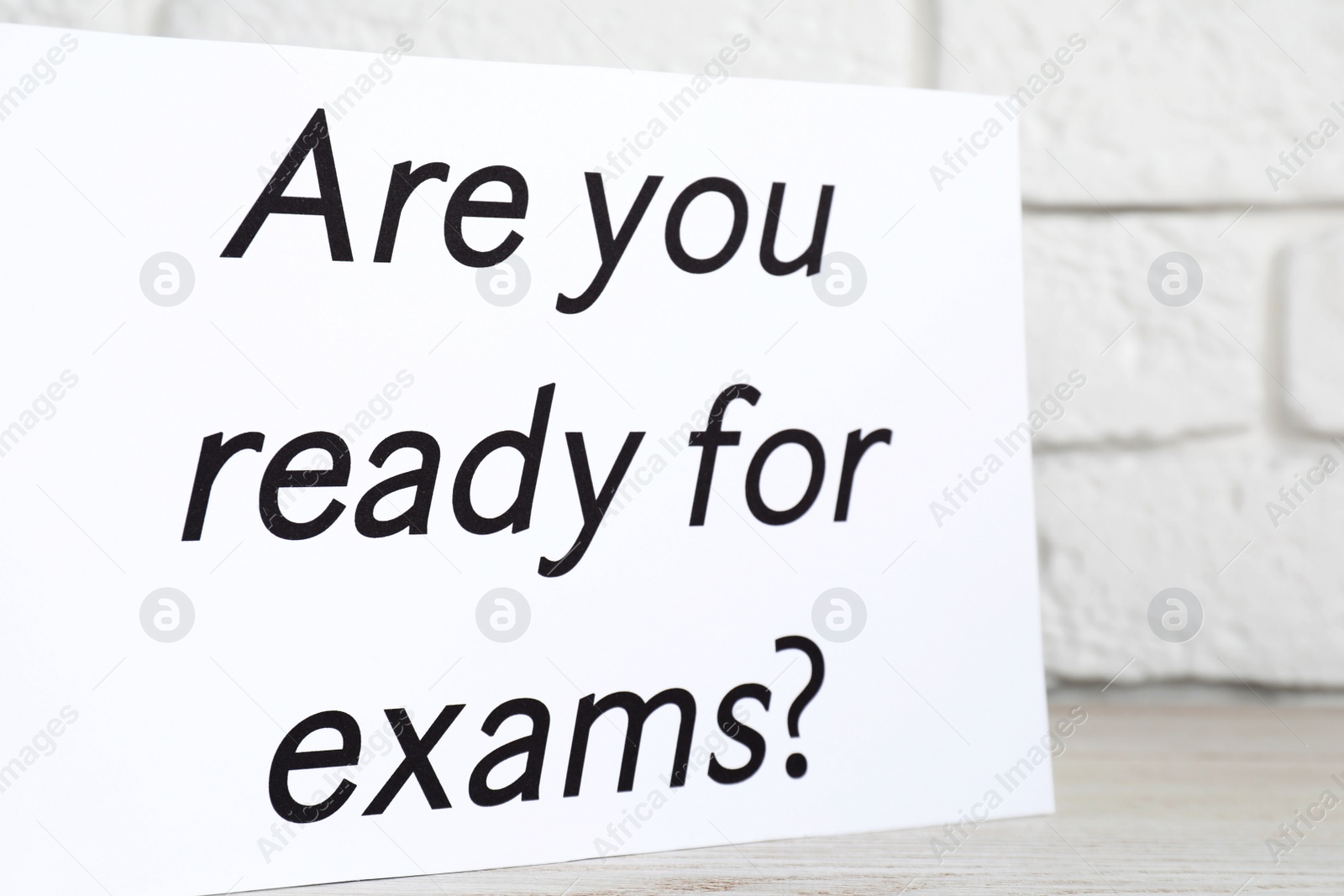 Photo of Paper with question Are you ready for exams on white wooden table, closeup