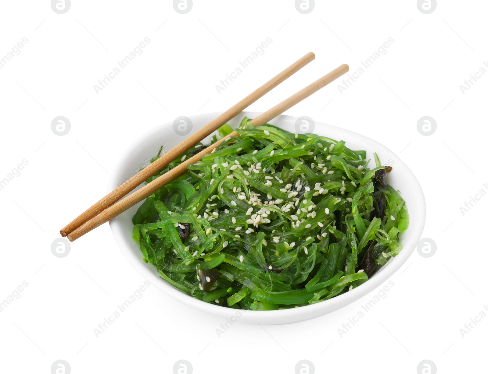 Photo of Tasty seaweed salad in bowl and chopsticks isolated on white