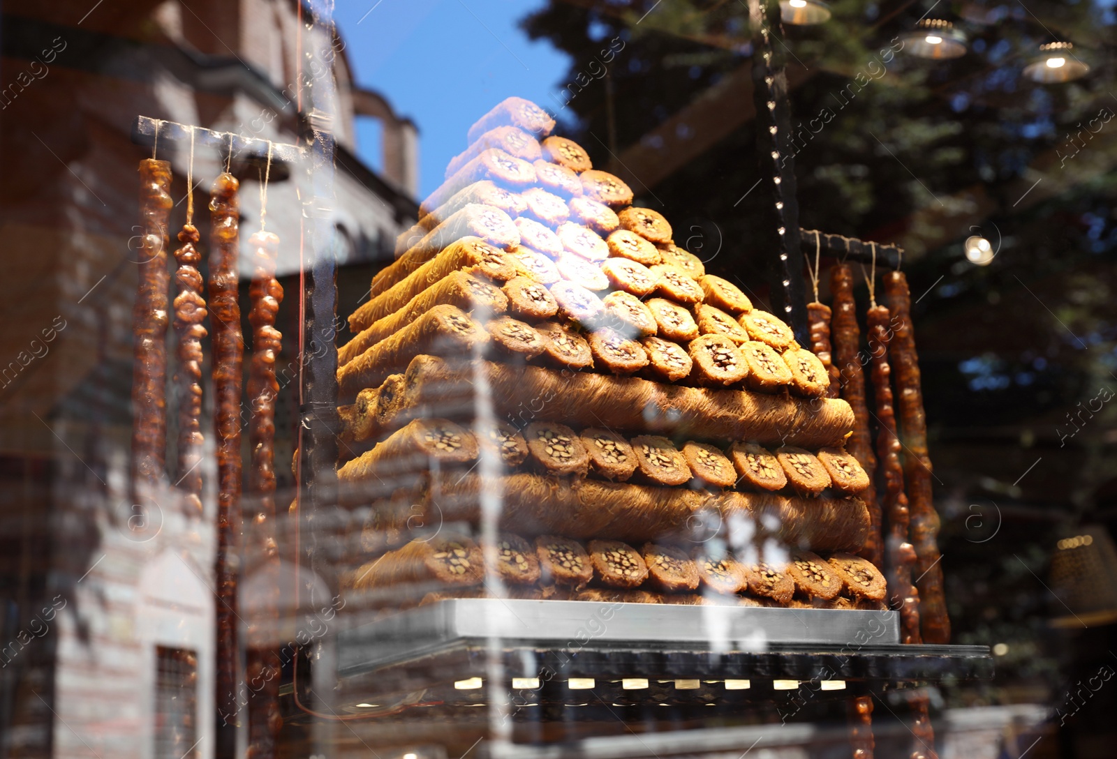 Photo of Shop with different sweets, view through window glass