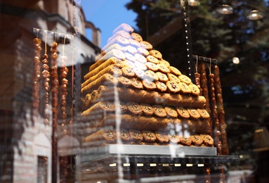 Photo of Shop with different sweets, view through window glass