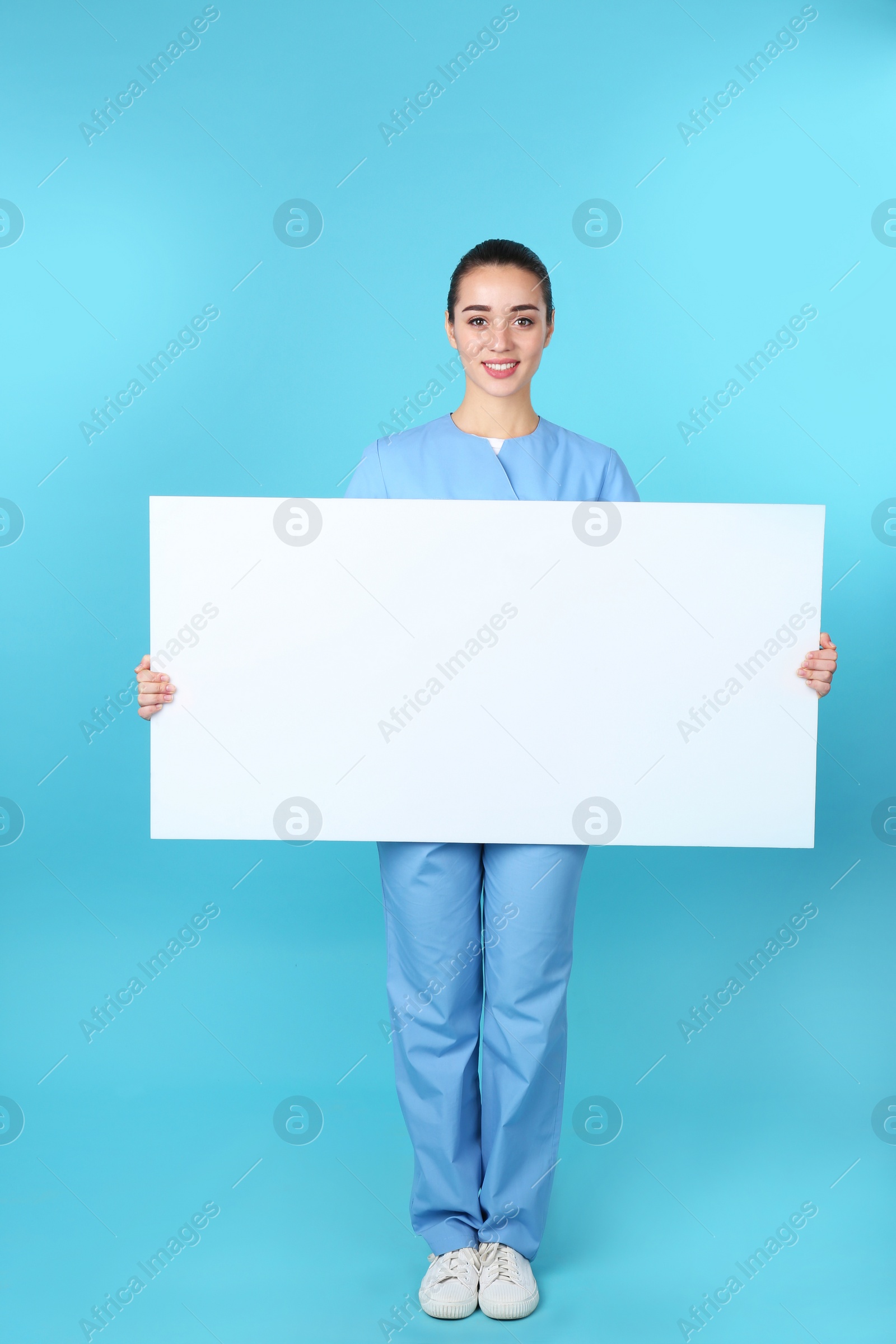 Photo of Medical student with blank poster on color background. Space for text
