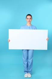 Medical student with blank poster on color background. Space for text