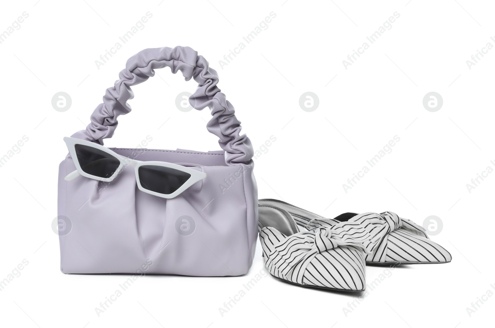 Photo of Stylish woman's bag, sunglasses and shoes isolated on white