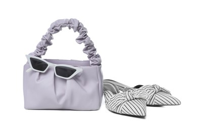 Photo of Stylish woman's bag, sunglasses and shoes isolated on white