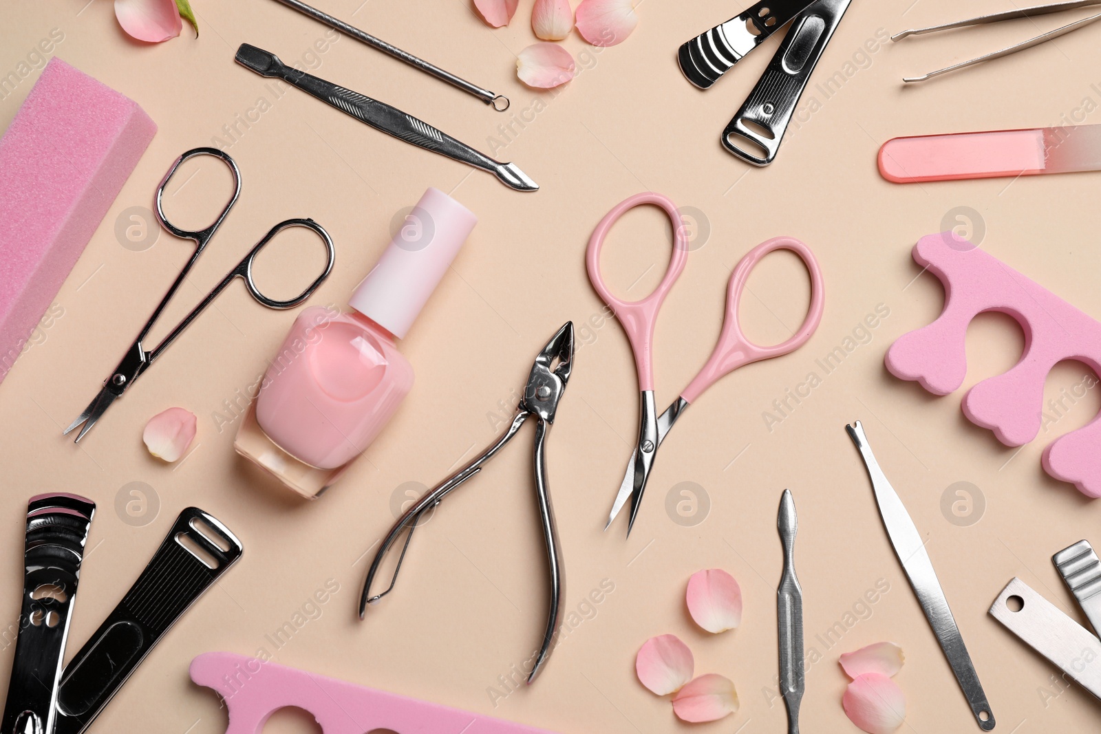 Photo of Composition with manicure and pedicure tools on beige background, flat lay