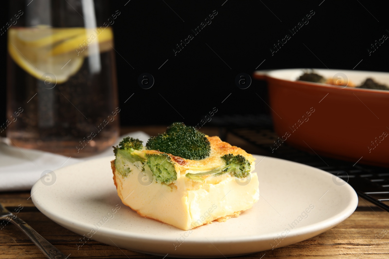 Photo of Tasty broccoli casserole served on wooden table