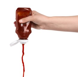 Photo of Woman pouring tasty ketchup from bottle isolated on white, closeup