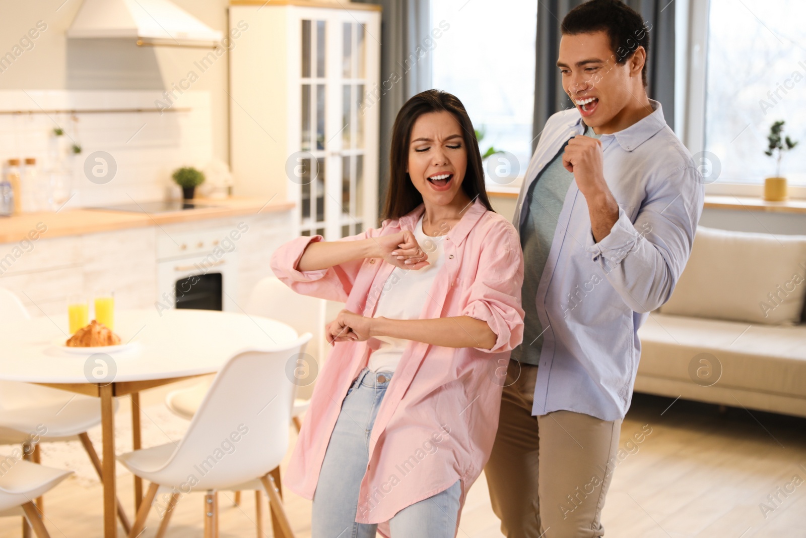 Photo of Lovely young interracial couple dancing at home