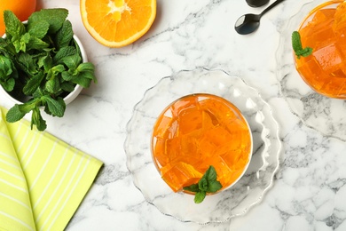 Flat lay composition with orange jelly in  bowls on marble table