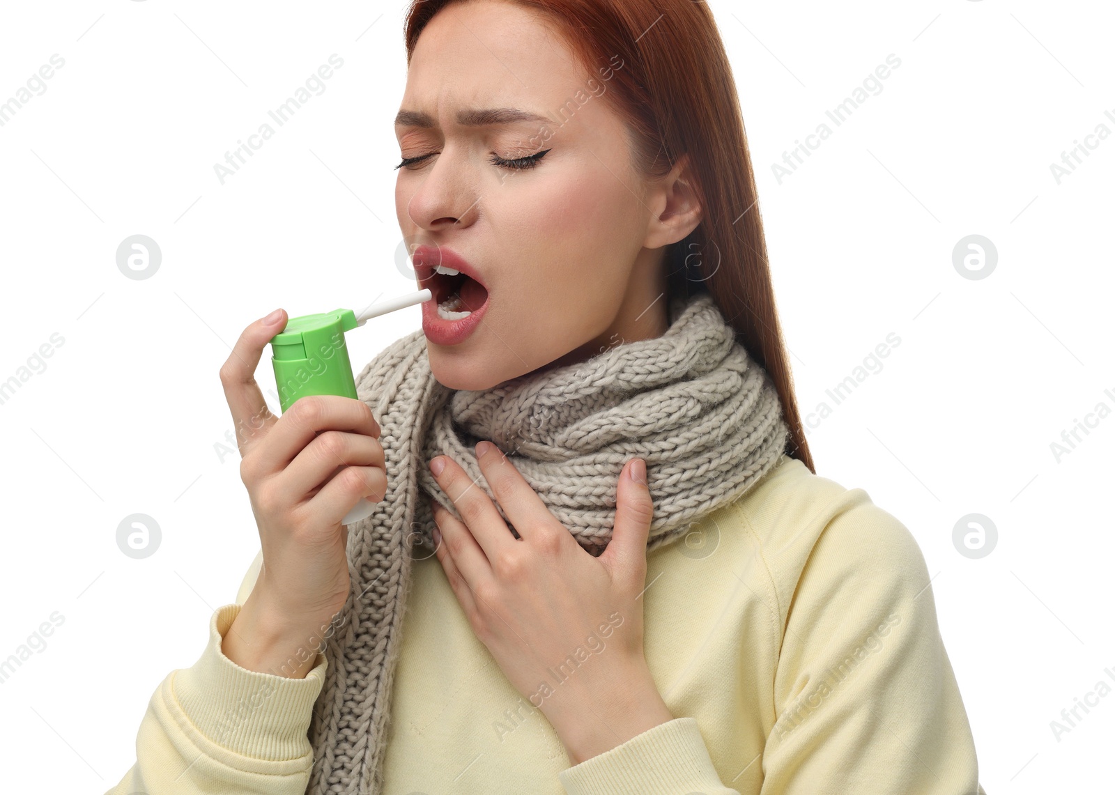 Photo of Young woman with scarf using throat spray on white background