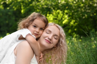 Photo of Beautiful mother with her cute daughter spending time together outdoors, space for text