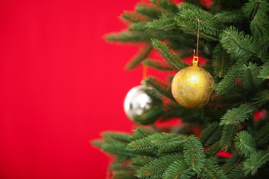 Photo of Beautifully decorated Christmas tree against color background, closeup