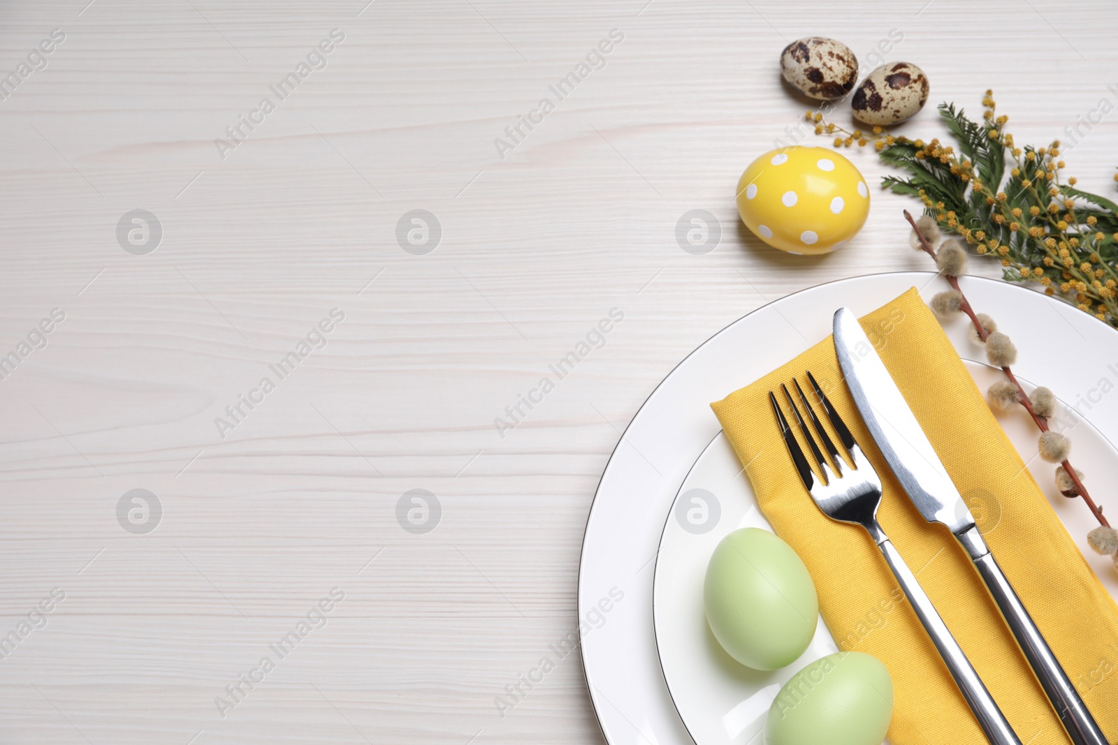 Photo of Festive Easter table setting with eggs on white wooden background, flat lay. Space for text